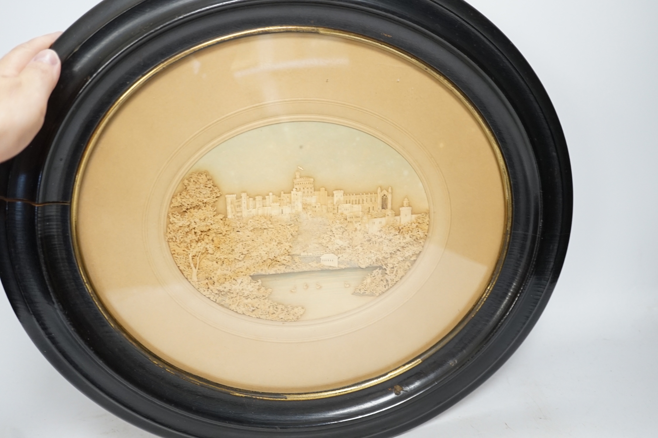 A framed and mounted oval cork picture of Windsor Castle, 8cm wide. Condition - some foxing to mount and background, frame needs attention